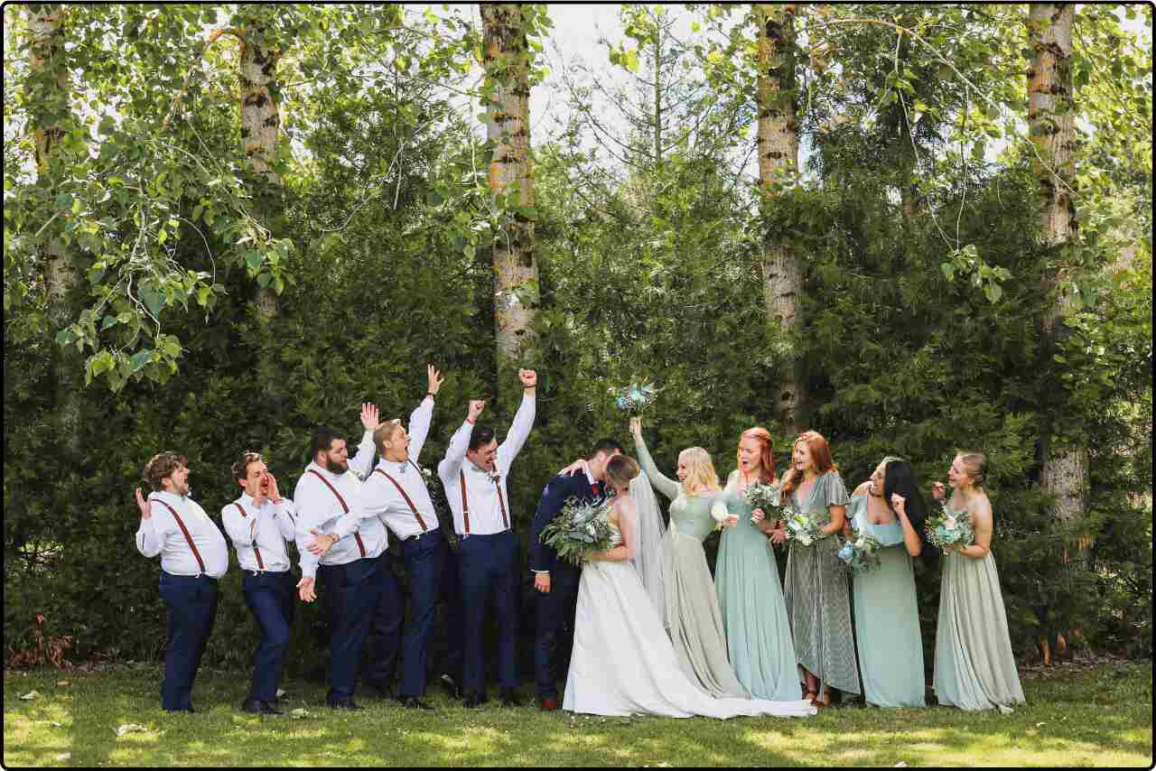 Wedding entourage posing together in their formal attire, featuring bridesmaids, groomsmen, and other key figures in a celebratory group photo